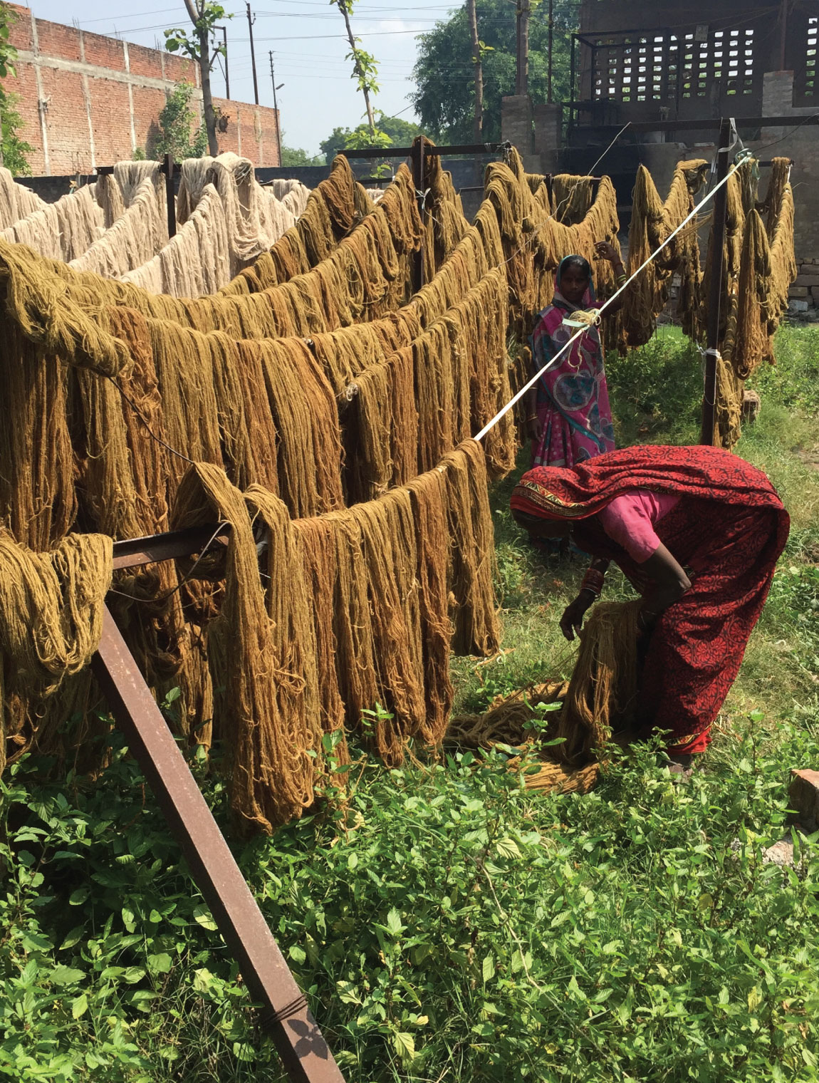 women standing by drying dyed wool